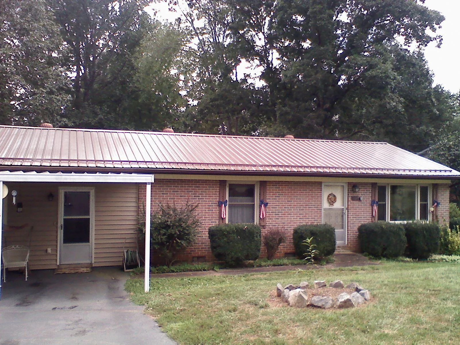 Bronze metal roof and carport on a brick ranch home — Roof Repair work by our crew in Somers